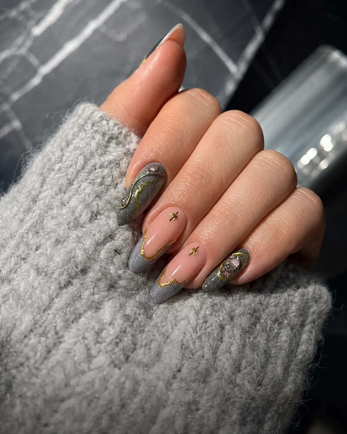 Soft grey and pink manicure photographed in a refined editorial setting